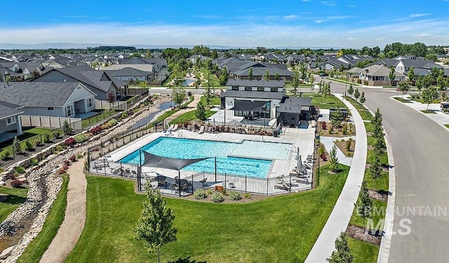 pool with a lawn, fence, and a residential view