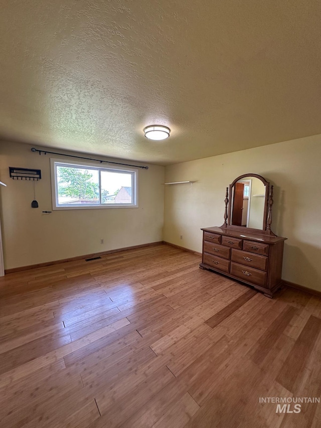 812 Thompson Ave, Nyssa, OR 97913 - unfurnished bedroom featuring wood finished floors, baseboards, and a textured ceiling