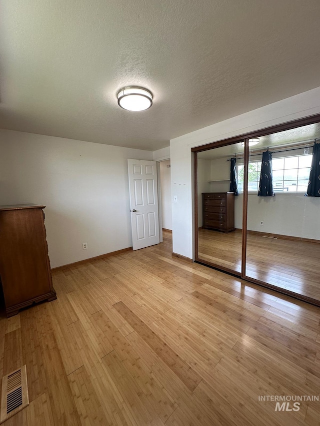 812 Thompson Ave, Nyssa, OR 97913 - unfurnished bedroom with light wood-style flooring, a closet, a textured ceiling, and baseboards