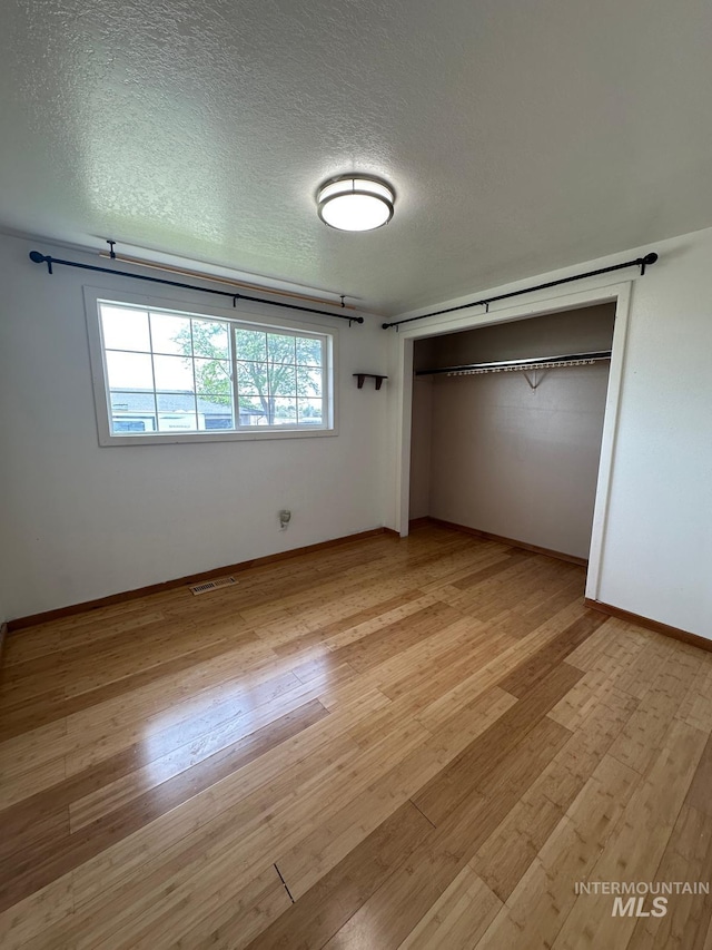 812 Thompson Ave, Nyssa, OR 97913 - unfurnished bedroom with light wood finished floors, a textured ceiling, a closet, and baseboards