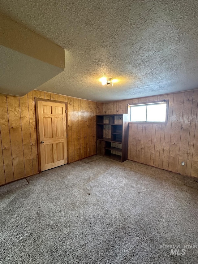 812 Thompson Ave, Nyssa, OR 97913 - unfurnished bedroom with wooden walls, a textured ceiling, and carpet