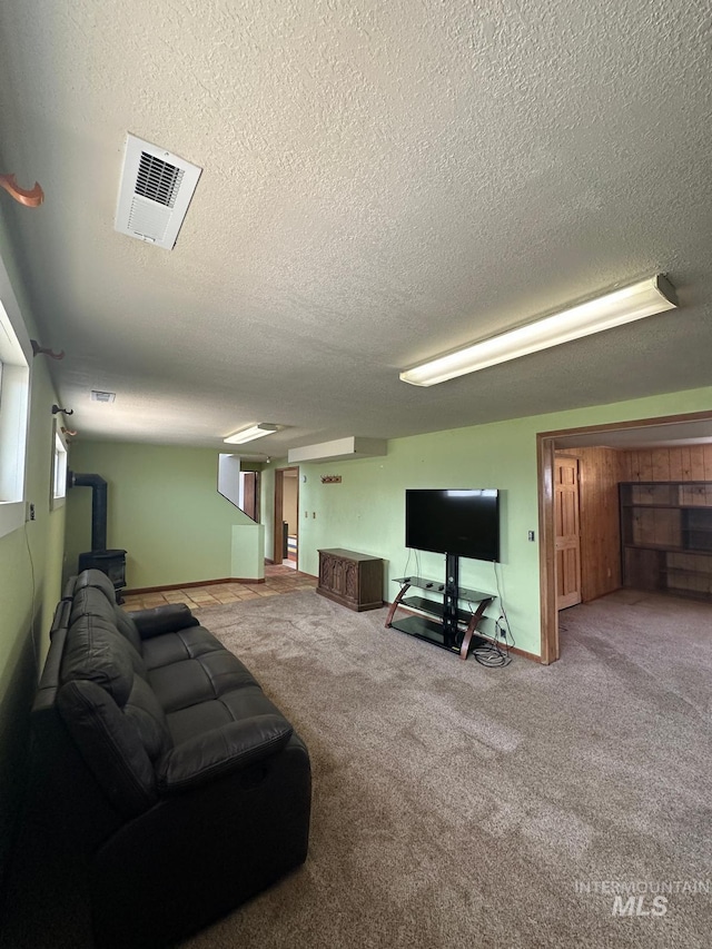 812 Thompson Ave, Nyssa, OR 97913 - living room with a wood stove, carpet, a textured ceiling, and baseboards