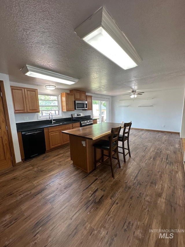 812 Thompson Ave, Nyssa, OR 97913 - kitchen featuring stainless steel appliances, a textured ceiling, dark wood finished floors, and plenty of natural light
