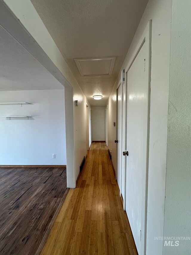 812 Thompson Ave, Nyssa, OR 97913 - corridor with wood finished floors, baseboards, and attic access