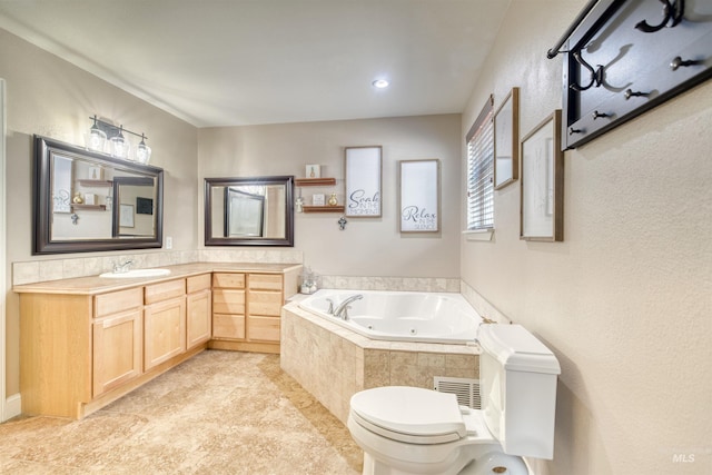 full bathroom featuring visible vents, toilet, vanity, and a tub with jets