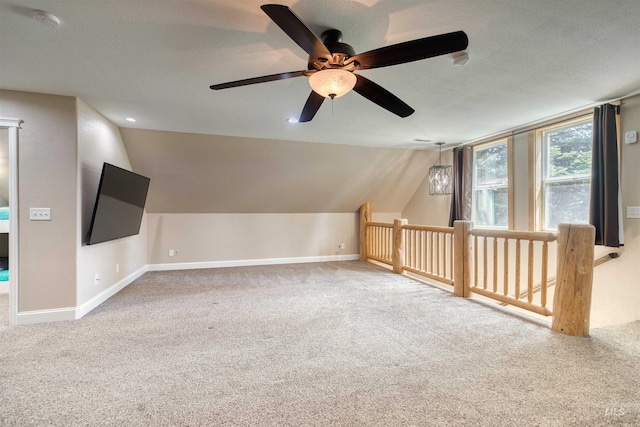 additional living space with baseboards, lofted ceiling, carpet, and ceiling fan