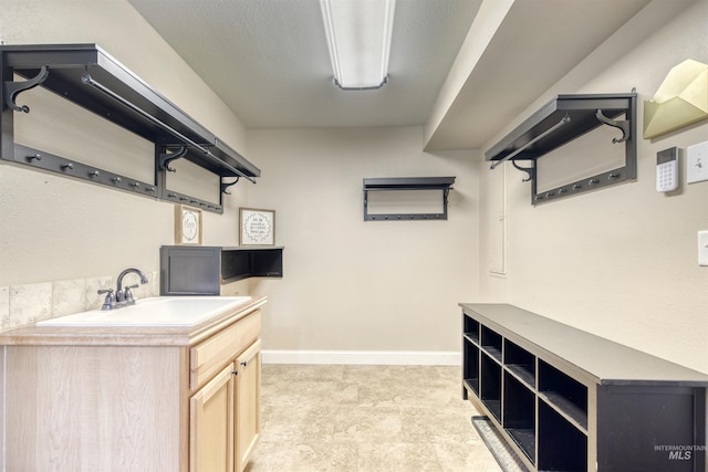 laundry room featuring baseboards and a sink