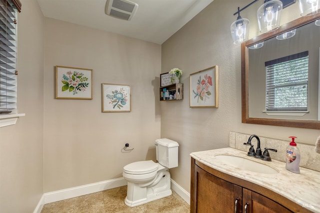 bathroom with baseboards, visible vents, toilet, and vanity