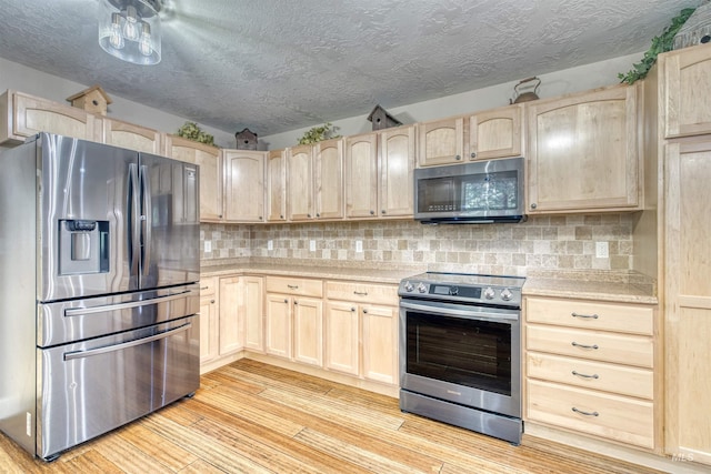 kitchen featuring light countertops, light brown cabinetry, and appliances with stainless steel finishes