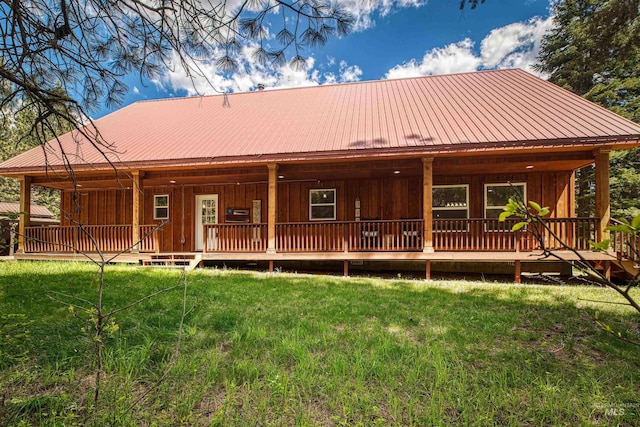 view of front of home featuring board and batten siding, a front lawn, and metal roof