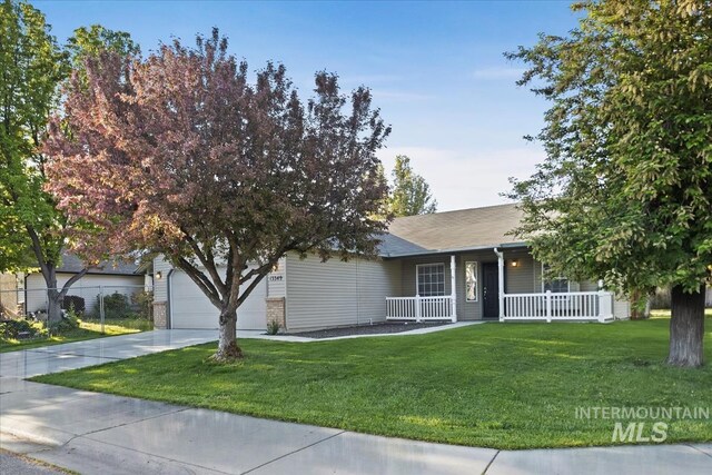 single story home with covered porch, driveway, a front yard, and a garage
