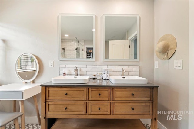 4680 N Maplestone Ave, Meridian, ID 83646 - bathroom featuring double vanity, baseboards, a tile shower, and backsplash