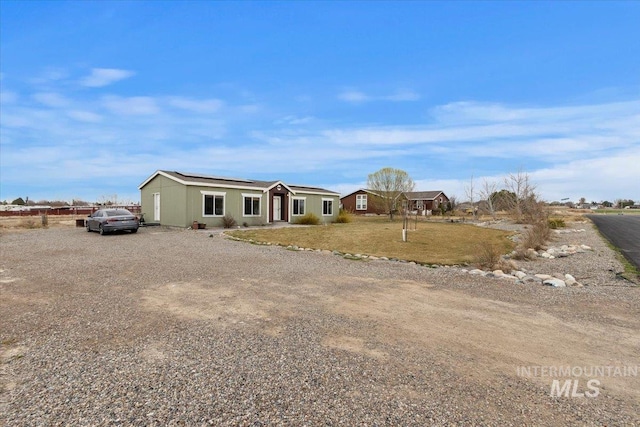 3834 N 2381 E, Filer, ID 83328 - view of front of home with roof mounted solar panels, gravel driveway, and a front lawn