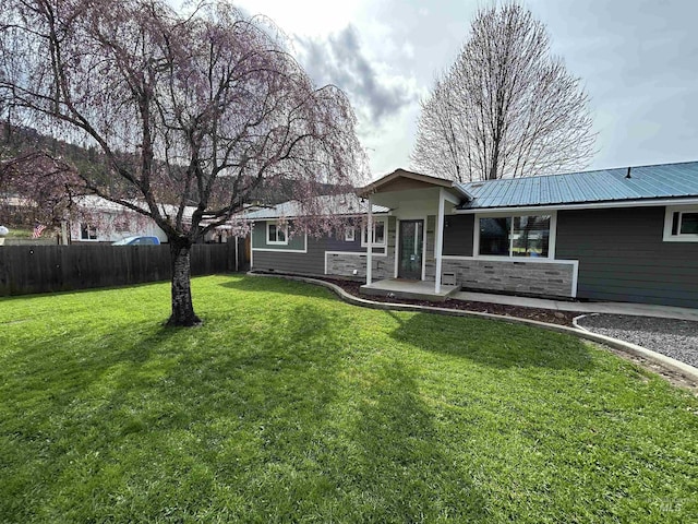 139 119th St, Orofino, ID 83544 - rear view of house with a yard, metal roof, stone siding, and fence