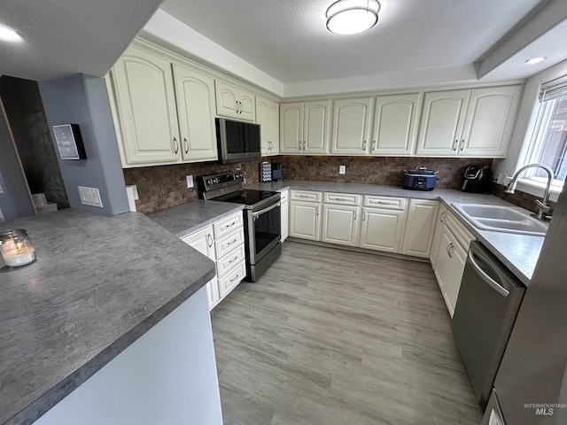 139 119th St, Orofino, ID 83544 - kitchen featuring tasteful backsplash, a sink, a peninsula, light wood finished floors, and stainless steel appliances