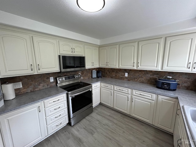 139 119th St, Orofino, ID 83544 - kitchen featuring tasteful backsplash, light wood-style floors, a sink, and stainless steel appliances
