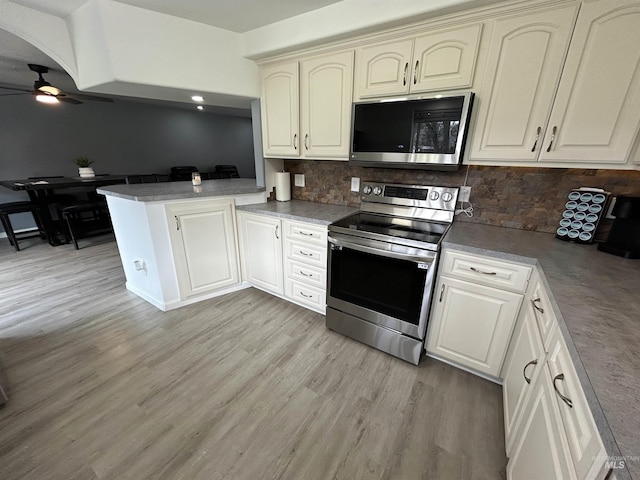 139 119th St, Orofino, ID 83544 - kitchen featuring light wood-style flooring, a peninsula, stainless steel electric range, and a ceiling fan