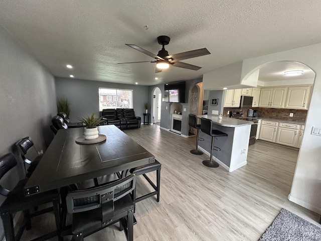 139 119th St, Orofino, ID 83544 - dining room with arched walkways, ceiling fan, a textured ceiling, and light wood-style floors