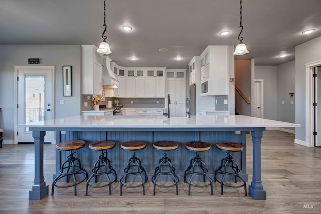 3330 E 4050 N, Twin Falls, ID 83301 - kitchen featuring tasteful backsplash, baseboards, white cabinetry, light wood-style floors, and a breakfast bar area