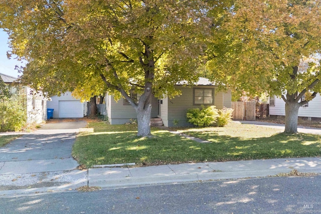 view of property hidden behind natural elements featuring a front lawn