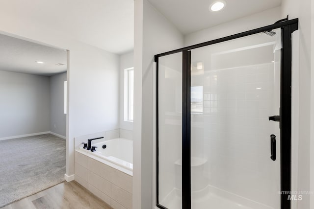 4372 N Magical Creek Ave, Meridian, ID 83646 - bathroom with baseboards, a stall shower, wood finished floors, and a garden tub