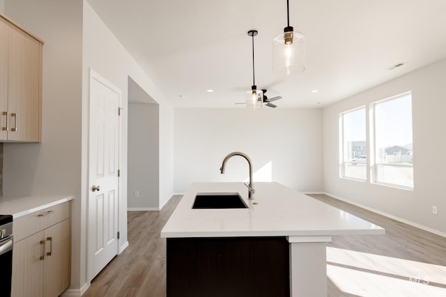 4372 N Magical Creek Ave, Meridian, ID 83646 - kitchen featuring visible vents, a sink, light wood-type flooring, a ceiling fan, and a center island with sink