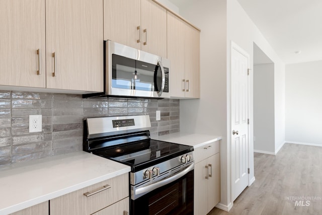 4372 N Magical Creek Ave, Meridian, ID 83646 - kitchen featuring light wood finished floors, decorative backsplash, light brown cabinetry, and appliances with stainless steel finishes