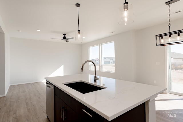 4372 N Magical Creek Ave, Meridian, ID 83646 - kitchen featuring a kitchen island with sink, stainless steel dishwasher, light wood finished floors, pendant lighting, and a sink