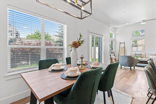 1447 N Pineview Ln, Boise, ID 83713 - dining area with wood finished floors, a textured ceiling, and a chandelier