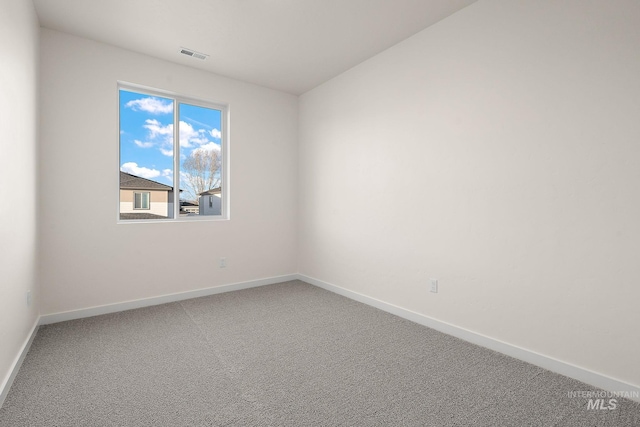 spare room featuring visible vents, baseboards, and carpet