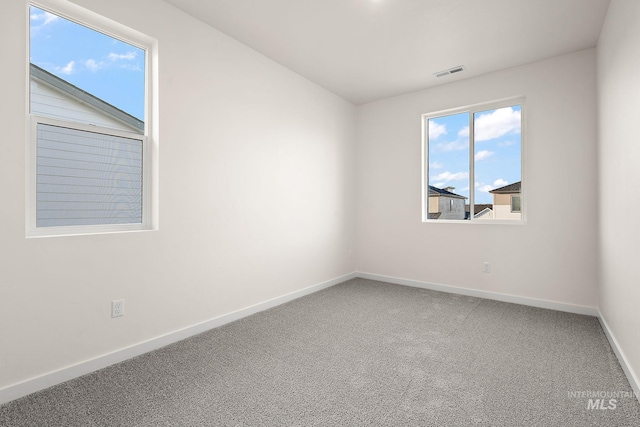 spare room with visible vents, baseboards, and carpet