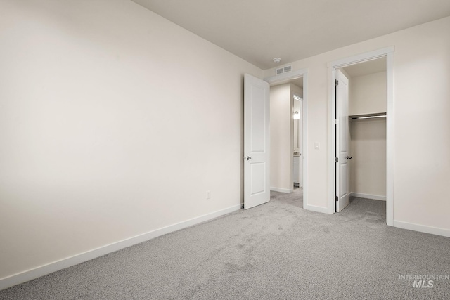 unfurnished bedroom featuring baseboards, carpet floors, and visible vents