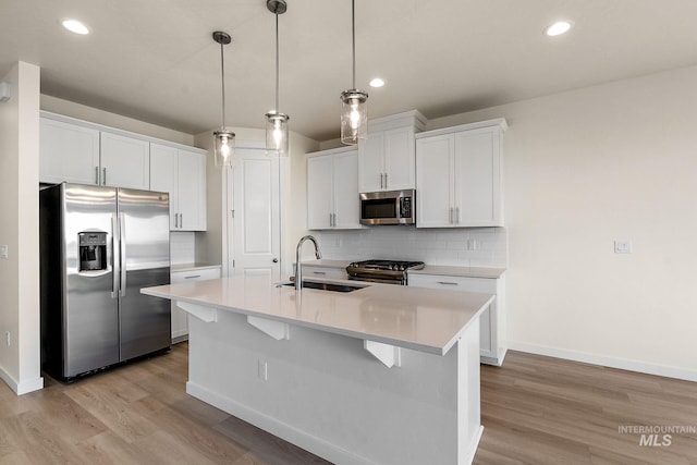 kitchen with light countertops, tasteful backsplash, appliances with stainless steel finishes, and a sink