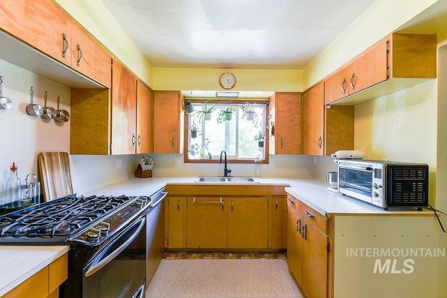 1021 E 5th St, Moscow, ID 83843 - kitchen with gas stove, light countertops, dishwasher, and brown cabinetry