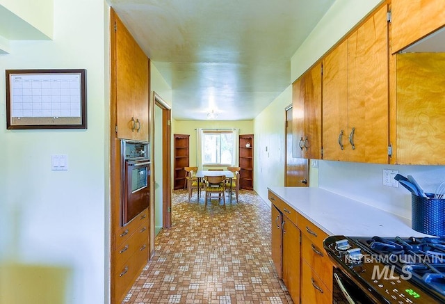 1021 E 5th St, Moscow, ID 83843 - kitchen featuring black oven, light countertops, brown cabinets, and stove