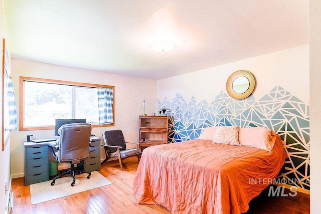 1021 E 5th St, Moscow, ID 83843 - bedroom with wood finished floors, a desk, and a baseboard radiator