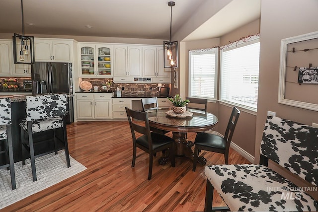 dining area with lofted ceiling and hardwood / wood-style flooring