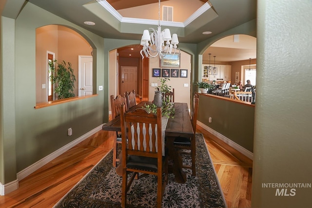 dining room featuring light wood-type flooring, a chandelier, and ornamental molding