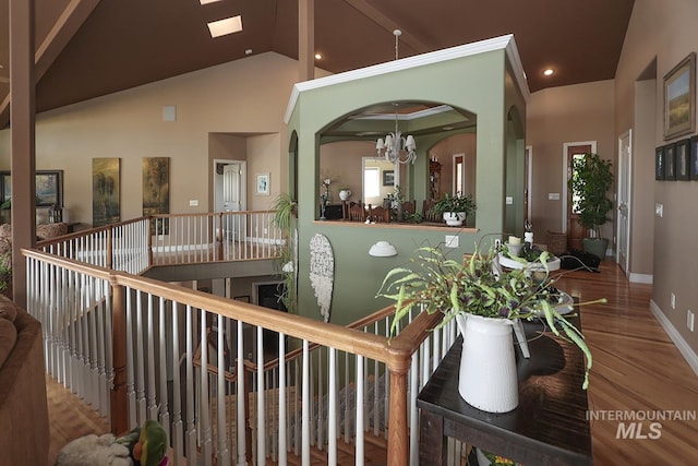 interior space featuring an inviting chandelier, high vaulted ceiling, hardwood / wood-style flooring, and a skylight