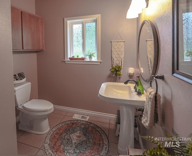 bathroom with toilet and tile patterned floors