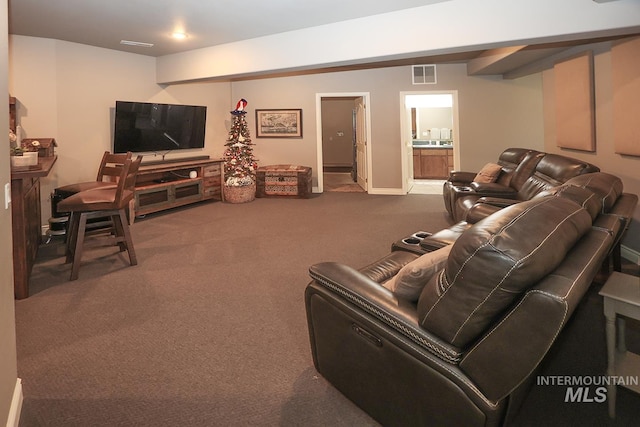 carpeted living room with beamed ceiling