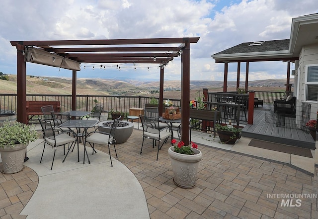 view of patio / terrace with a fire pit, a mountain view, and a pergola