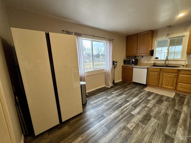 kitchen with dark hardwood / wood-style flooring, sink, pendant lighting, and white dishwasher