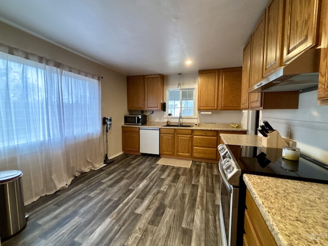 kitchen featuring dark hardwood / wood-style flooring, sink, light stone counters, and stainless steel appliances