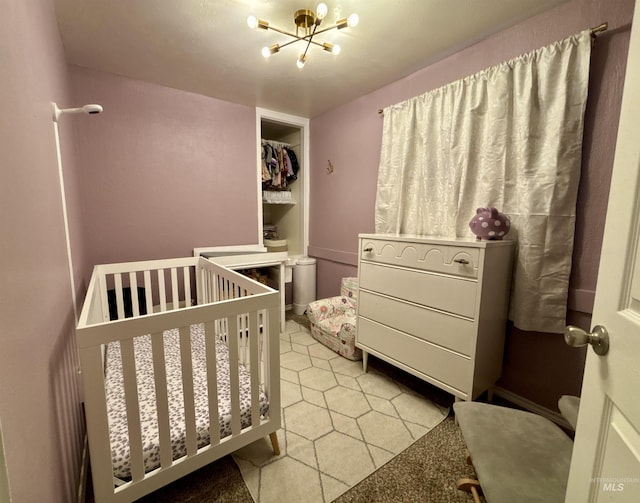 bedroom featuring a notable chandelier and a crib