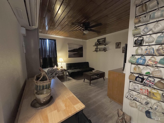 living room with crown molding, wood-type flooring, wooden ceiling, and ceiling fan