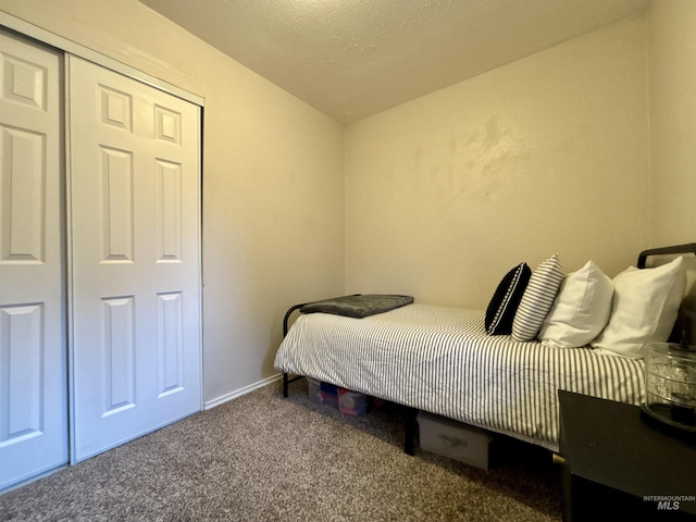 bedroom featuring a closet, a textured ceiling, and carpet