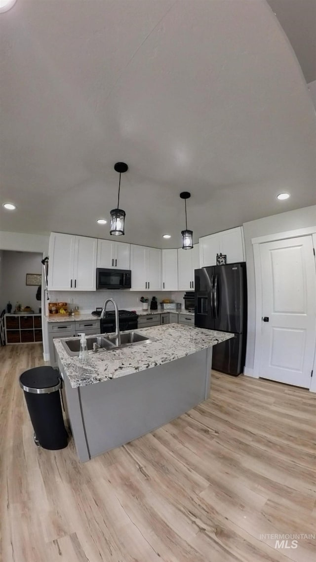 808 Adell Ave, Filer, ID 83328 - kitchen featuring a center island with sink, light wood-type flooring, white cabinets, a sink, and black appliances