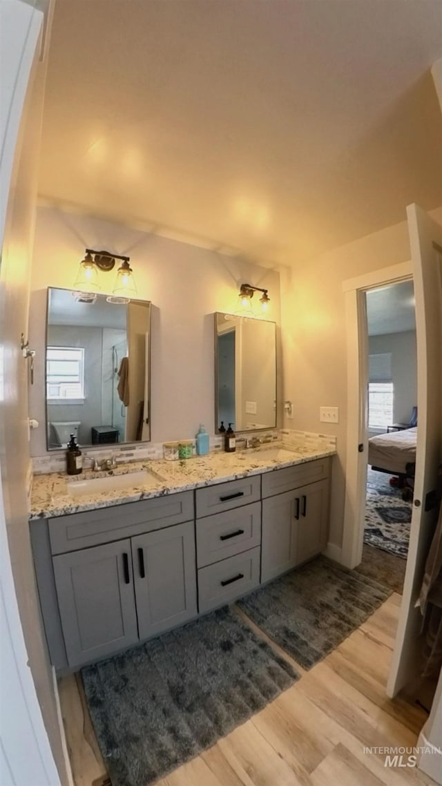 808 Adell Ave, Filer, ID 83328 - ensuite bathroom featuring double vanity, a sink, wood finished floors, and a wealth of natural light