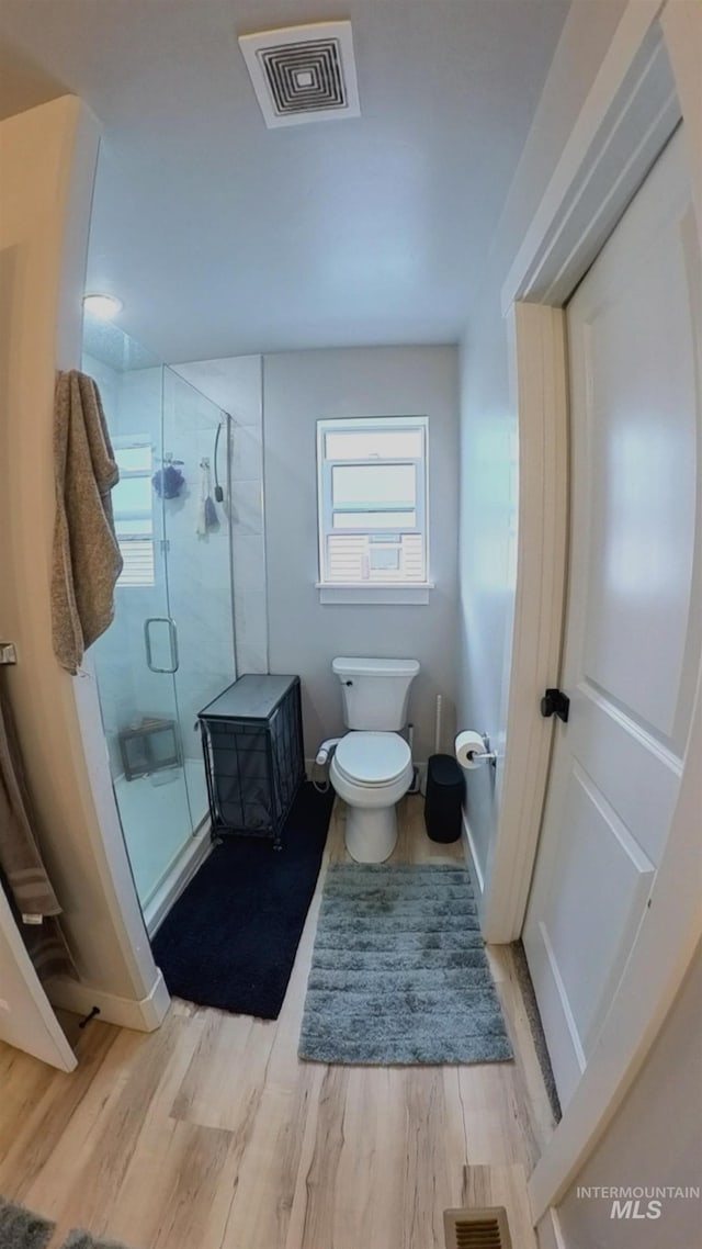 808 Adell Ave, Filer, ID 83328 - bathroom with a stall shower, toilet, wood finished floors, and visible vents